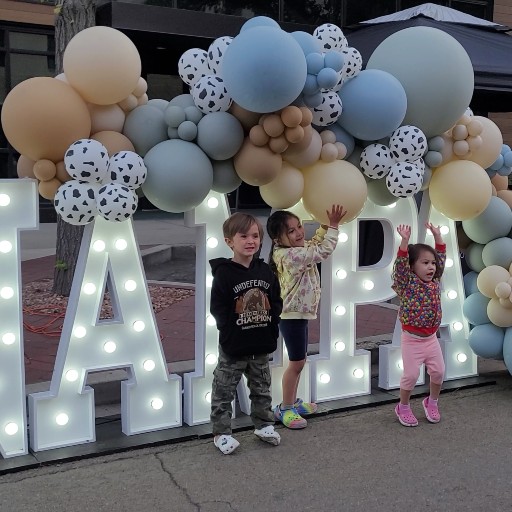 Children standing in front of a Nampa sign with balloons during the Third Thursday event in downtown Nampa, Idaho