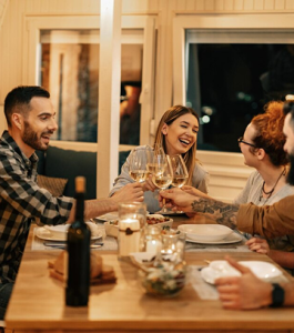 Friends enjoying dinner and conversation together in a warm, welcoming dining setting in Nampa, Idaho
